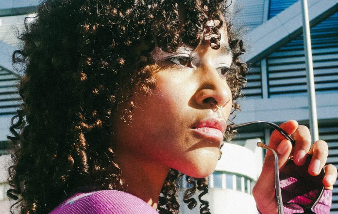 Uche Yara photographed in a purple top and sunglasses in her hand, photo by Mala Kolumna